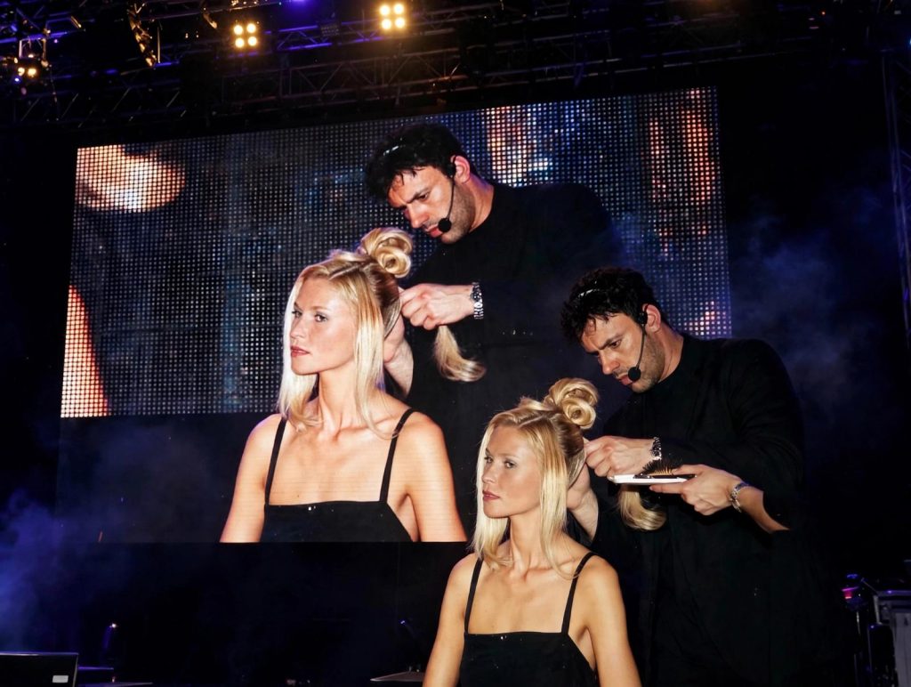 Perruquer crea un pentinat en directe sobre un escenari