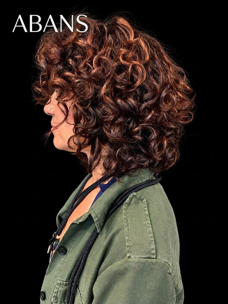 Perfil de dona amb cabells arrissats castanys voluminosos